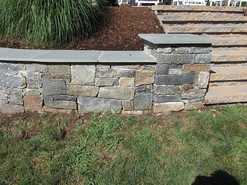 Custom stone feature wall bringing structure and definition to an outdoor space